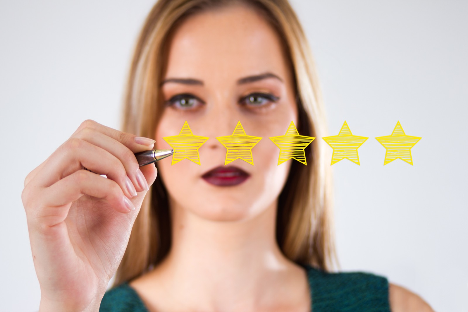 Person drawing a five-star rating, representing ongoing review